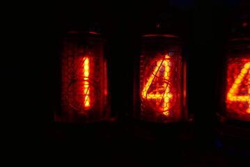 Retro Nixie lamp indicator clock on dark background. The Nixie tube indicator of the numbers of...