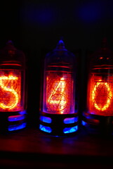 Retro Nixie lamp indicator clock on dark background. The Nixie tube indicator of the numbers of...