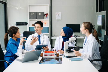  Doctor Talks With Professional Head Nurse or Surgeon, They Use Digital tablet Computer. Diverse Team of Health Care Specialists Discussing Test Result on desk .