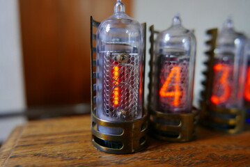 Retro Nixie lamp indicator clock on dark background. The Nixie tube indicator of the numbers of retro style.