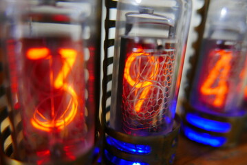 Retro Nixie lamp indicator clock on dark background. The Nixie tube indicator of the numbers of retro style.