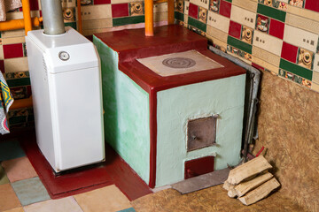 Stove and gas boiler for heating a rural house. Different types of fuel for heating in winter.