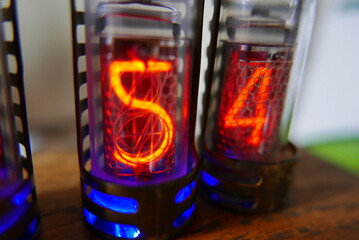 Retro Nixie lamp indicator clock on dark background. The Nixie tube indicator of the numbers of retro style.