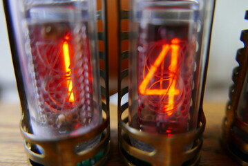 Retro Nixie lamp indicator clock on dark background. The Nixie tube indicator of the numbers of...
