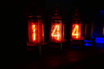 Retro Nixie lamp indicator clock on dark background. The Nixie tube indicator of the numbers of retro style.