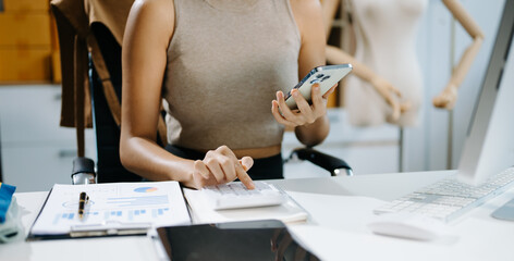 Woman using laptop, smartphone, tablet and writing on the notepad at office