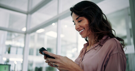 Fototapeta premium Mature, business woman and smile with phone in office for communication, text message or positive feedback on email. Professional, person and happy with smartphone for notification, chat or good news