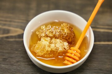 Close up view bowl with honey and honeycomb.