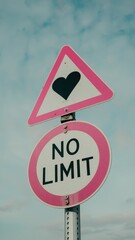 Street Sign with NO LIMIT and Heart Symbol Against Sky