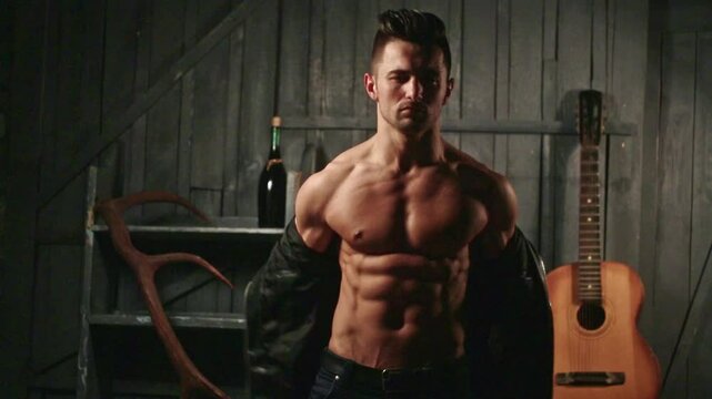 Topless guy undressed shirt. Young sexy man with muscular body takes off his shirt. Sexy male model. Seductive guy. Handsome shirtless man. Muscular male fit body. Male fashion model.