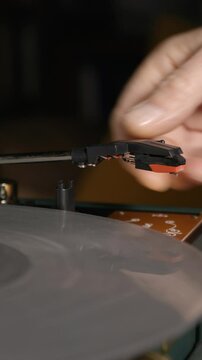 Vintage turntable close-up. Needle glides across the spinning silver record. 4k vertical video.