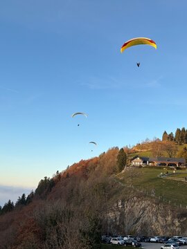 Parapente au dessus du Lac d' Annecy. Vol de parapente en montagne au dessus du brouillard. Sport extr&ecirc;me. Voler le soir au dessus de la brume avec un coucher de soleil.