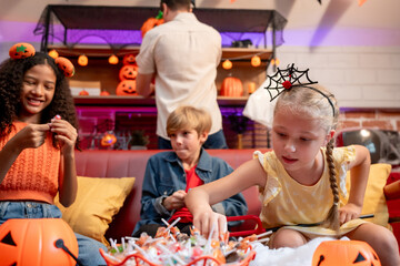 Fototapeta premium Multiracial family celebrating Halloween party together in house. 