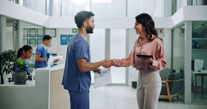 Doctor, meeting and tablet with handshake for contract, agreement or hiring nurse at hospital. Man, woman or medical colleagues shaking hands for recruitment, deal or teamwork together at clinic