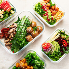 Glass containers with fresh vegan food, ready for meal prepping.