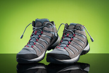 studio shoot a pair of black gray hiking boots, shoes isolated on natural green background