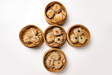 Assorted chinese dim sum dumpling on bamboo wooden basket bowl isolated over white background