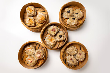 Assorted chinese dim sum dumpling on bamboo wooden basket bowl isolated over white background