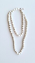 A pair of elegant white bead necklaces displayed on a light background.