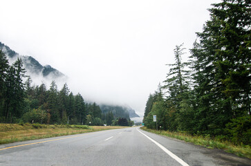 Highway in Hope  BC, Canada with cloud covered mountains in the background