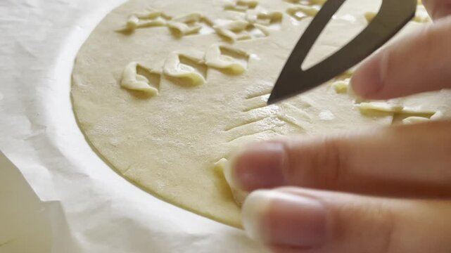 Cutting and carving traditional Icelandic flat bread called laufabrau&eth;