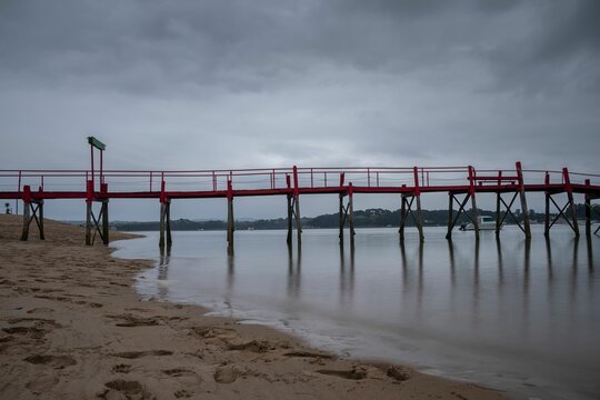 Pier on El Puntal beach in Somo, Santander, Spain with dramatic cloudy sky