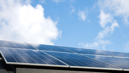 Aerial view of solar panel stand-alone photovoltaic plant system on cloudy blue sky background. Clean alternative energy power in nature concept, sustainable resources. Professional installation