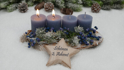 Dekoration zum zweiten Advent: Adventskranz mit blauen Kerzen. Auf einem Stern steht der Text wir wünschen einen schönen 2. Advent.	