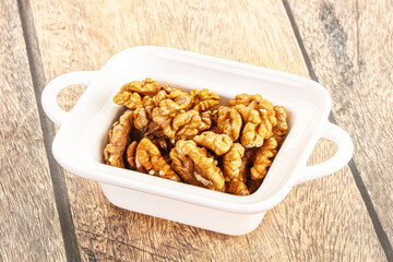 Cracked unshelled walnut in the bowl