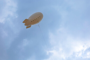 A balloon kite in the shape of an airship. Nice blue sky. Empty space on the ad bubble.