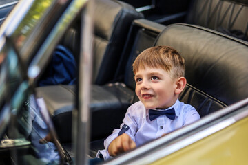 A five-year-old in a golden vintage car