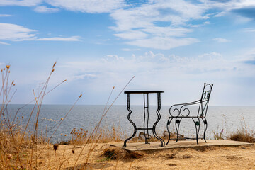 Lonely Mosaic Metal Coffee Table and Chair in an Outdoor Summer Sea Setting