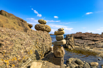 Stacked stones on a rocky beach, symbolizing balance and tranquility in nature.