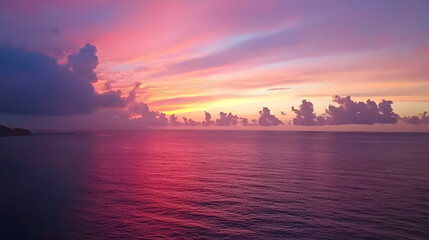 Naklejka premium vibrant sunset sky over ocean, filled with colorful clouds reflecting on water surface, creates serene and peaceful atmosphere