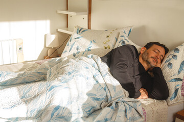 Relaxing mature man enjoying a peaceful sleep in his comfortable bed at home, reaping the benefits...