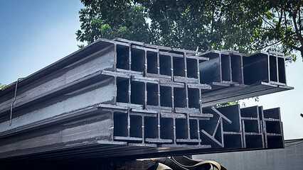 Metal profile beam in packs at the warehouse of metal products.Steel I-beam,Flange beam in warehouse,steel beams placed outside on a steel rack,steelwork,Structural steel