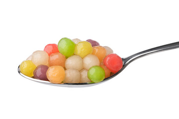 Metal spoon with colorful cooked tapioca pearls close up on white background