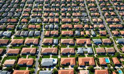 Fototapeta premium An aerial view of a suburban neighborhood with rows of houses and green lawns