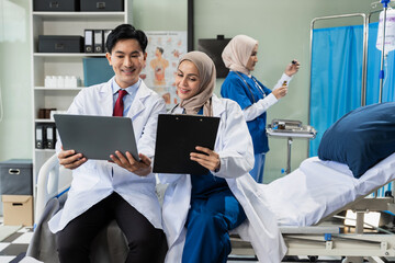 Obraz premium Doctors working together on laptop computer and tablet and medical stethoscope on clipboard on desk, electronics medical record system EMRs concept