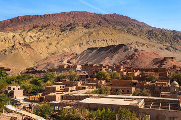 Scenic of the ancient Uyghurs village with flaming mountains on background in  Turpan, Xinjiang, China.