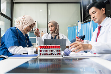 Doctors working together on laptop computer and tablet and medical stethoscope on clipboard on desk, electronics medical record system EMRs concept