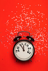 New Year 2025 background concept. 2024 changes to 2025 on an alarm clock on a colored background with festive glitter on New Year's Eve and Christmas.