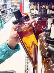 Bottle of whiskey in hands in store