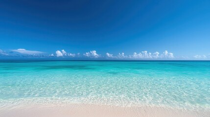 Fototapeta premium Serene Tropical Beach with Crystal Clear Water and Soft White Sand Under a Bright Blue Sky and Fluffy White Clouds on a Perfect Sunny Day