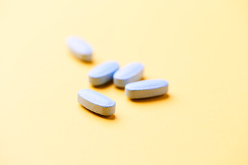 Multivitamin tablets on bright paper background. Close up. Copy space.	