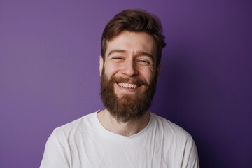 Obraz premium Caucasian Adult Man with Beard Smiling Happily on Purple Background