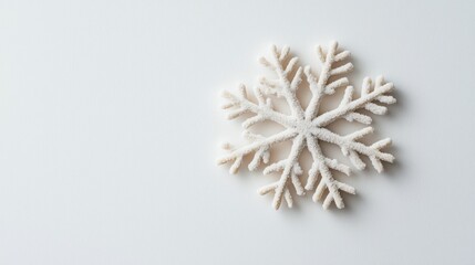 Detailed close-up of an individual snowflake on a clean white backdrop, emphasizing texture and structure in a minimalist winter aesthetic
