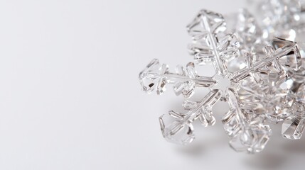 Fototapeta premium Macro shot of a beautiful, detailed snowflake isolated on a white background, highlighting natural symmetry and winter elegance