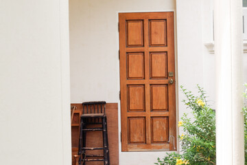 Wooden front door with small yellow flower pots,elegance house with concrete floor and loft style design at home,space for text.