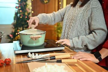 Cropped shot of couple making a special meal for Christmas in a decorated kitchen